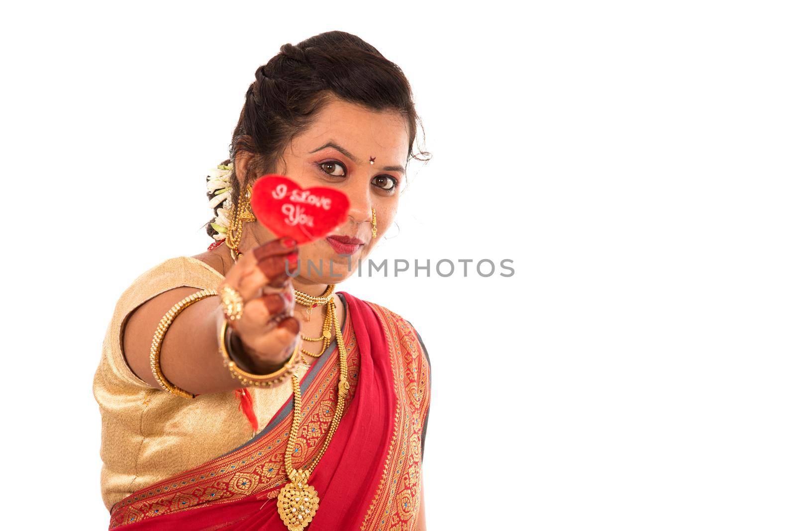 Traditional Beautiful Indian young girl in saree posing with Heart on white background