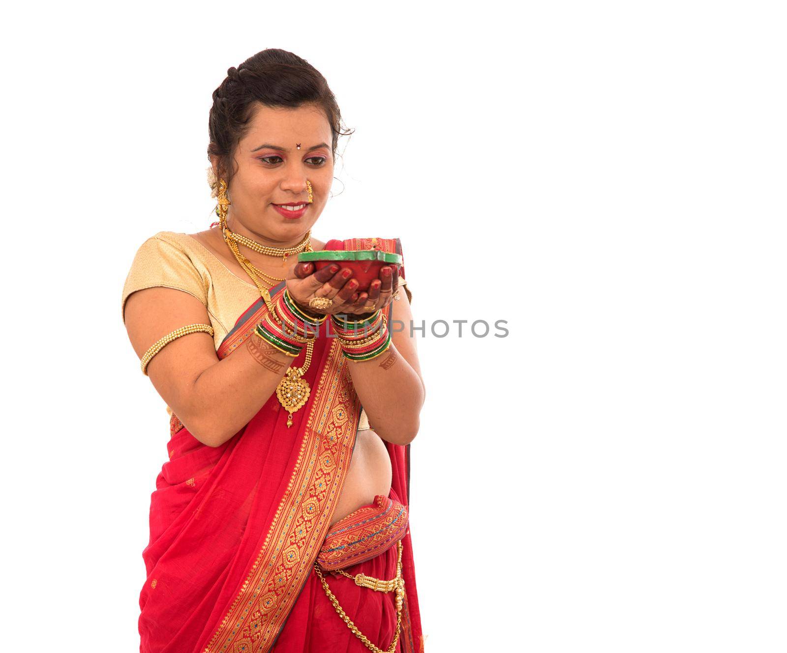 Portrait of a Indian Traditional Girl holding pooja thali with diya during festival of light on white background. Diwali or deepavali