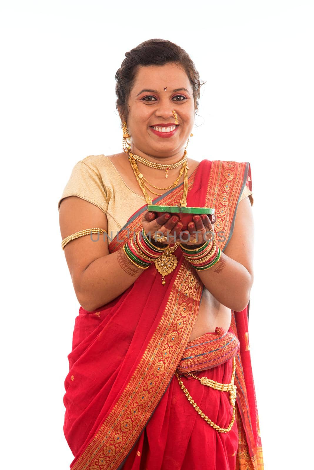 Portrait of a Indian Traditional Girl holding pooja thali with diya during festival of light on white background. Diwali or deepavali