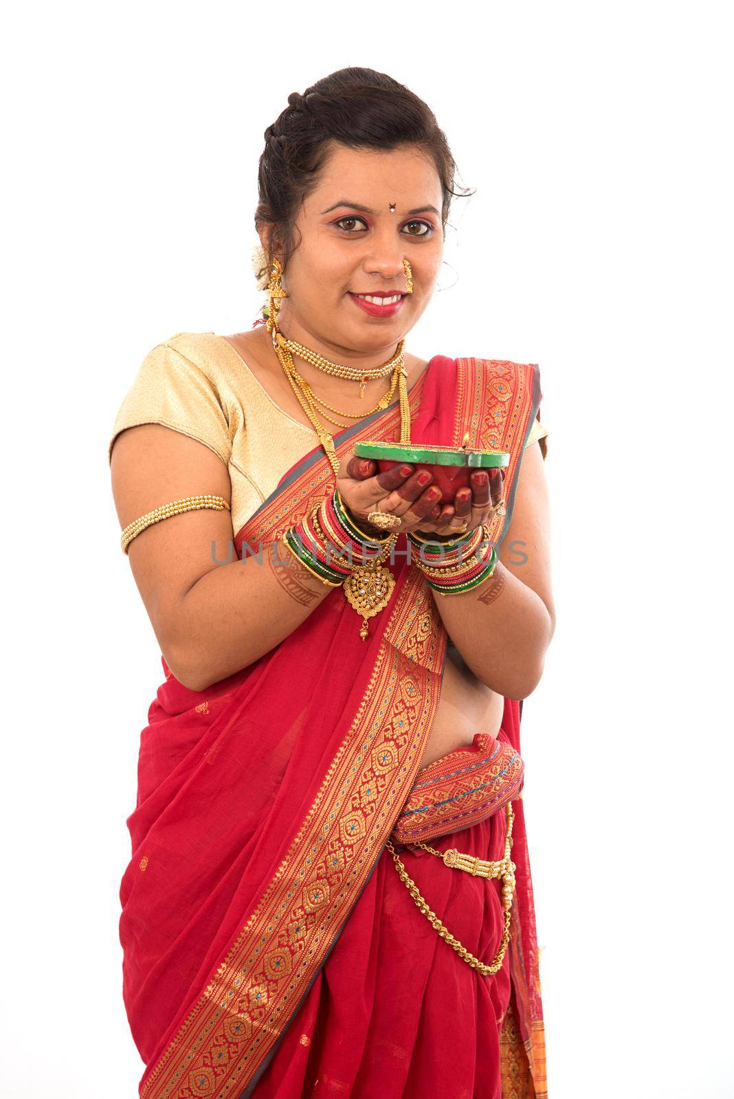 Portrait of a Indian Traditional Girl holding pooja thali with diya during festival of light on white background. Diwali or deepavali