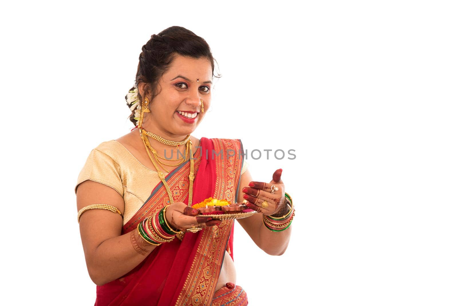 Portrait of a Indian Traditional Girl holding pooja thali with diya during festival of light on white background. Diwali or deepavali