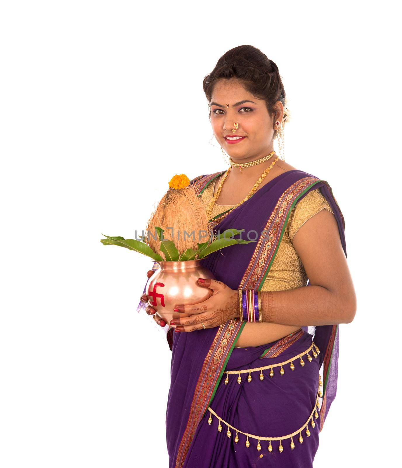 Indian Traditional Woman holding a traditional copper kalash, Indian Festival, copper kalash with coconut and mango leaf with floral decoration, essential in hindu puja.