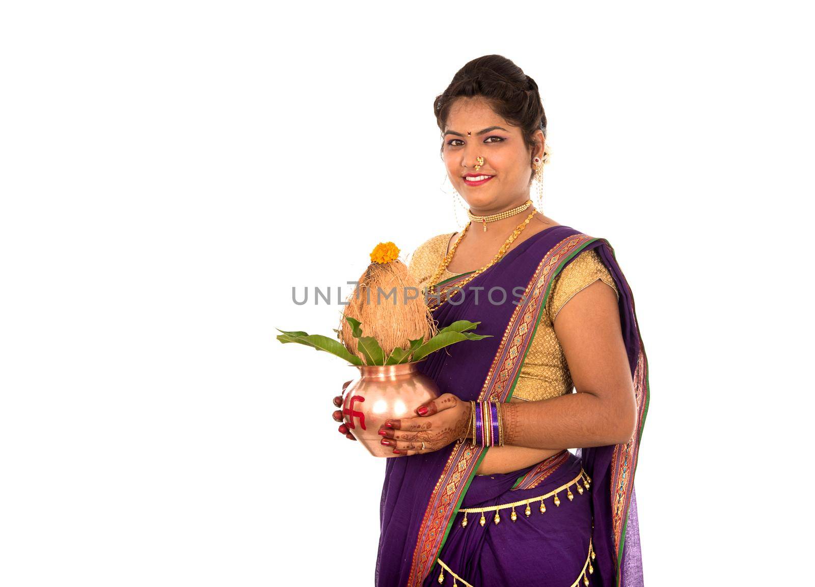 Indian Traditional Woman holding a traditional copper kalash, Indian Festival, copper kalash with coconut and mango leaf with floral decoration, essential in hindu puja.