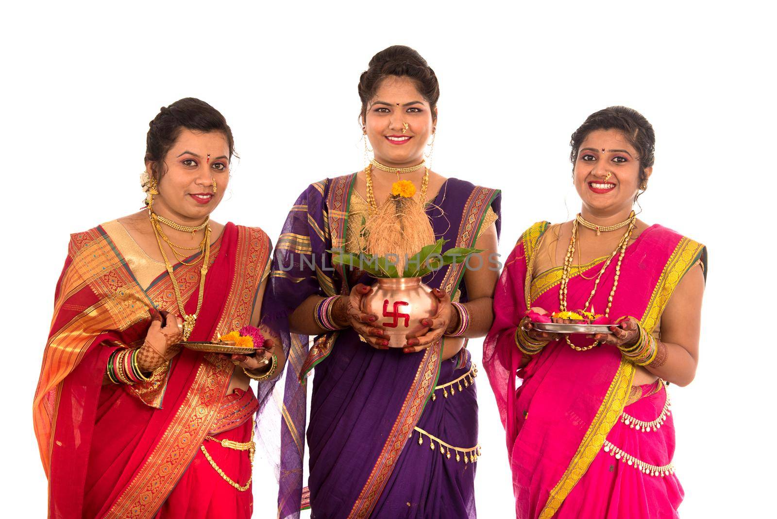 Indian Traditional Sisters performing worship, Indian Festival, copper kalash with coconut and mango leaf with floral decoration, essential in hindu puja.