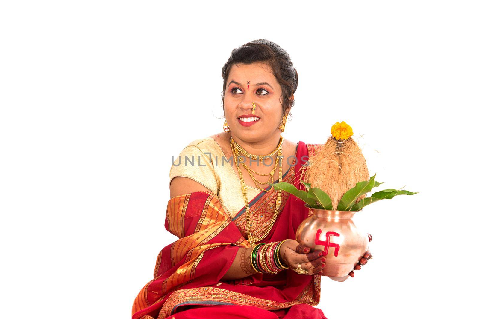 Indian Traditional Woman performing worship with copper kalash, Indian Festival, copper kalash with coconut and mango leaf with floral decoration, essential in hindu puja. by DipakShelare