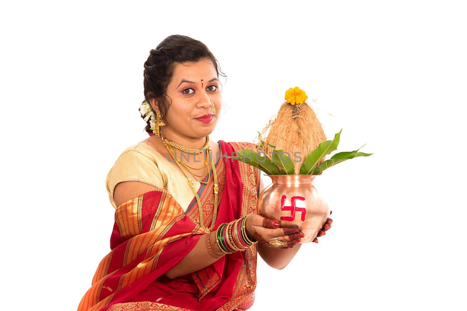 Indian Traditional Woman performing worship with copper kalash, Indian Festival, copper kalash with coconut and mango leaf with floral decoration, essential in hindu puja. by DipakShelare