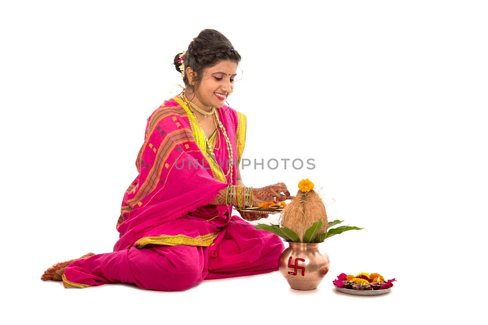 Indian Traditional Girl performing worship with copper kalash, Indian Festival, copper kalash with coconut and mango leaf with floral decoration, essential in hindu puja.