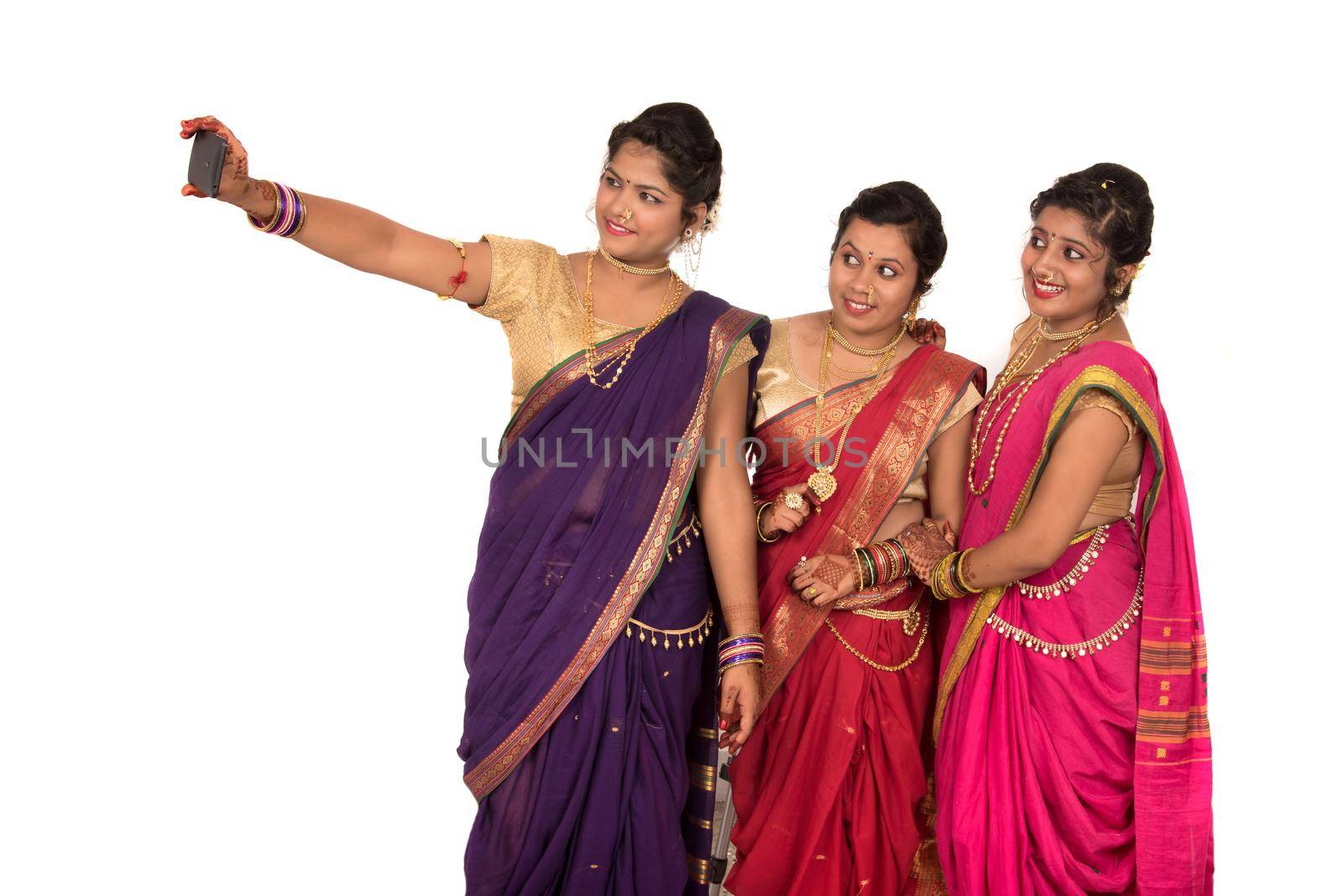 Indian traditional girls taking selfie with smartphone on white background by DipakShelare