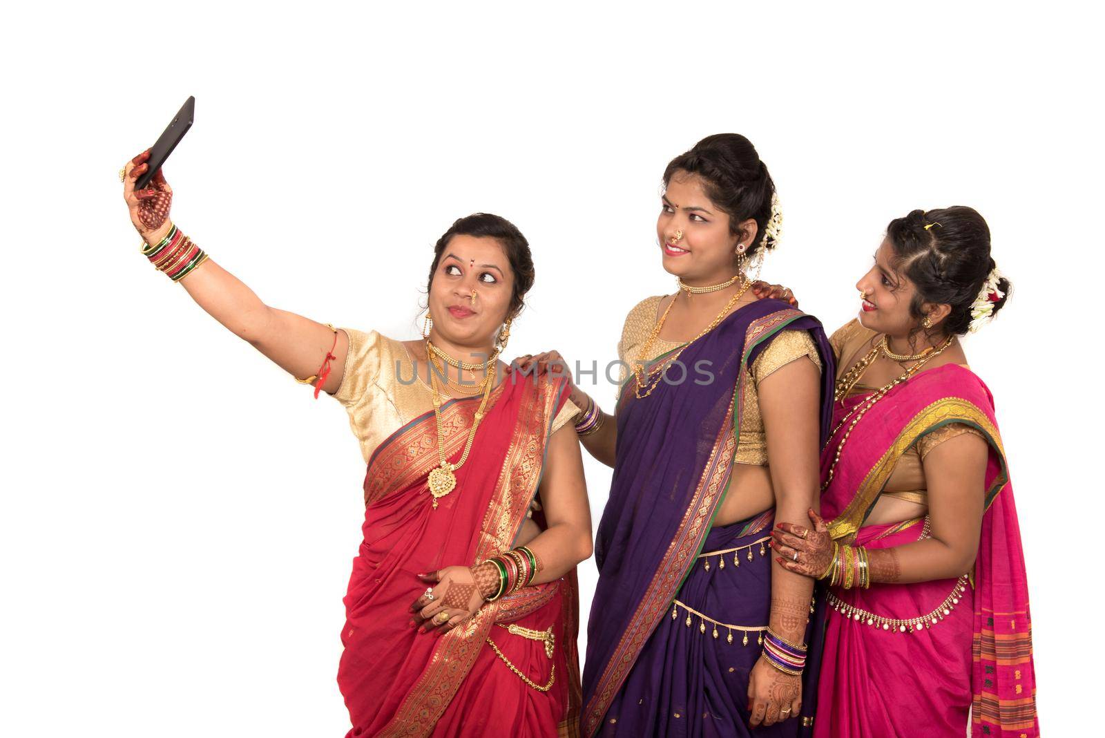 Indian traditional girls taking selfie with smartphone on white background by DipakShelare