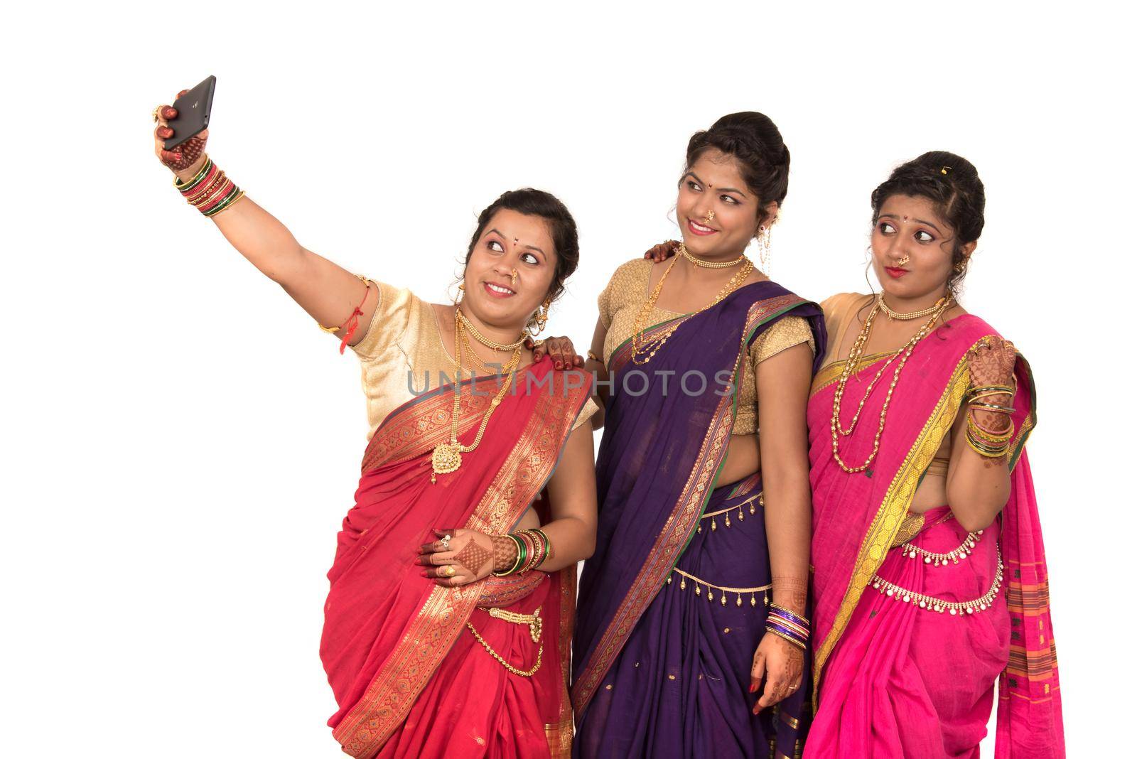 Indian traditional girls taking selfie with smartphone on white background