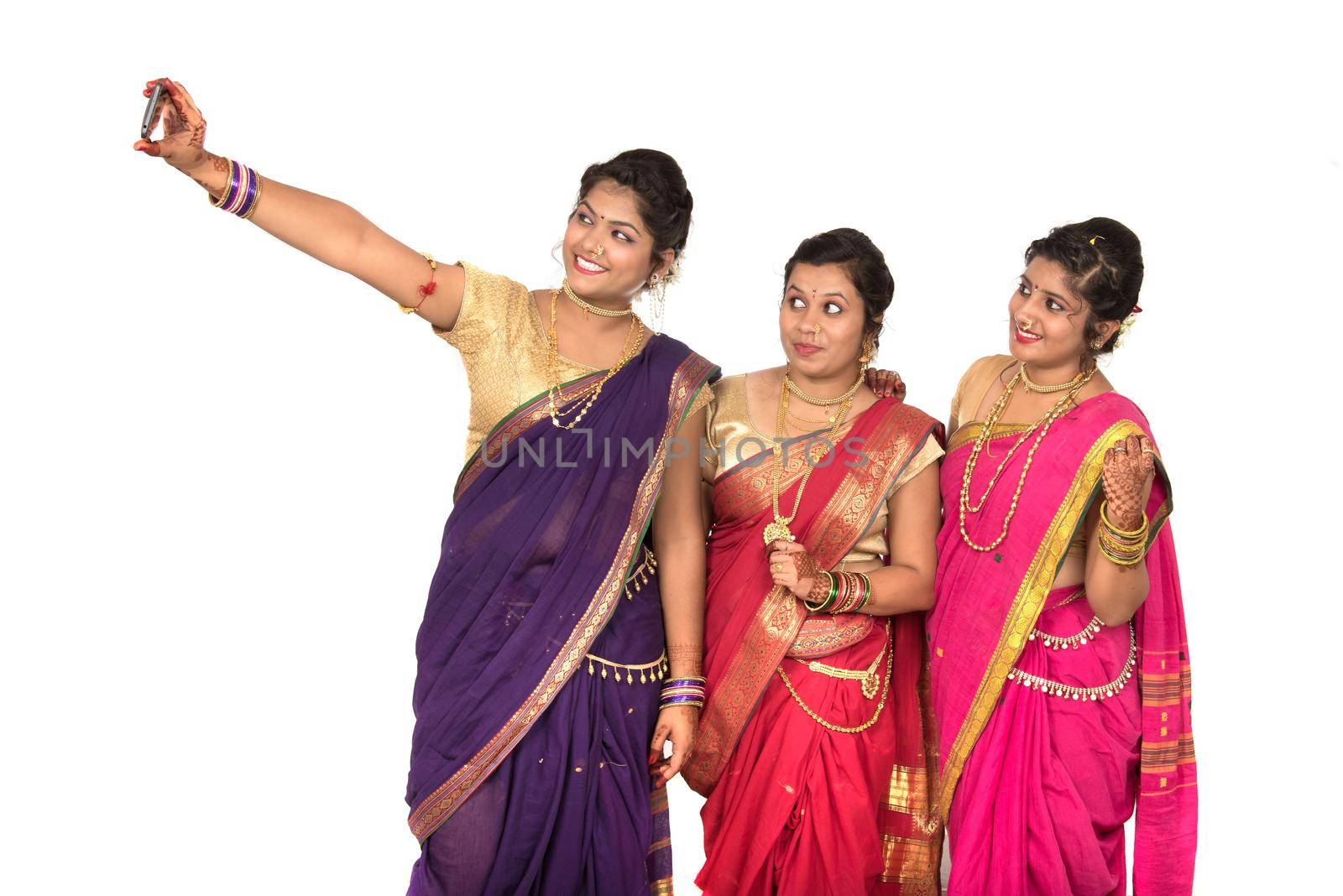 Indian traditional girls taking selfie with smartphone on white background by DipakShelare