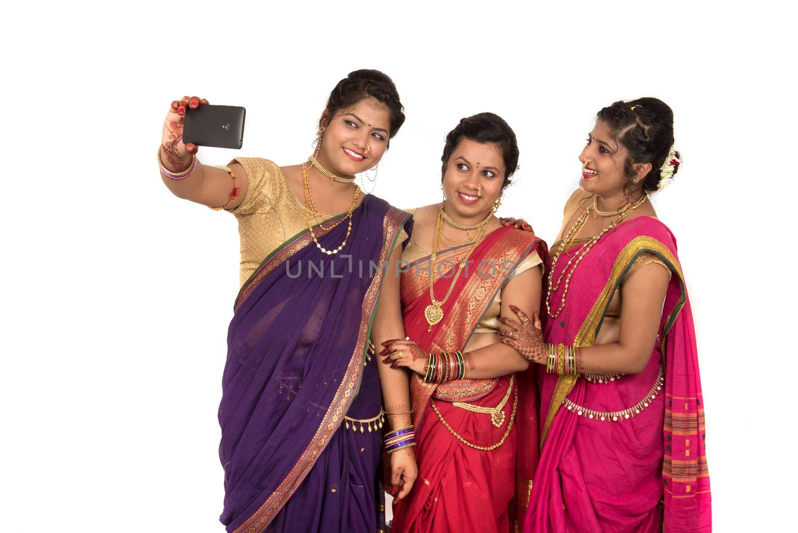 Indian traditional girls taking selfie with smartphone on white background