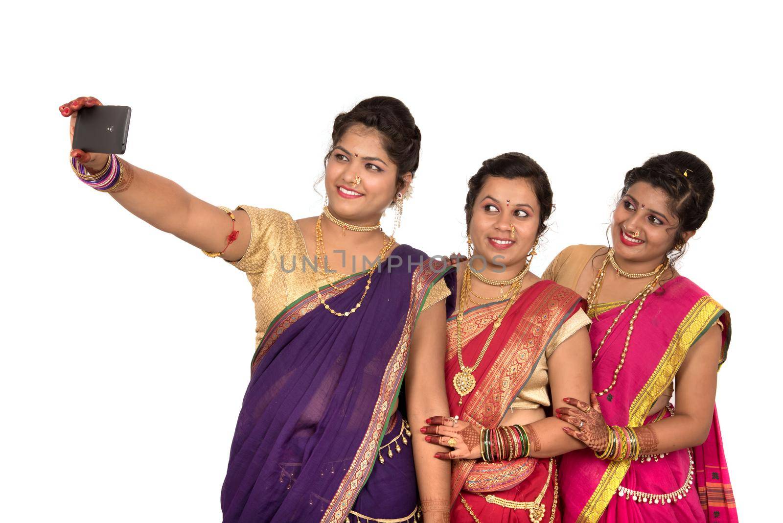 Indian traditional girls taking selfie with smartphone on white background by DipakShelare