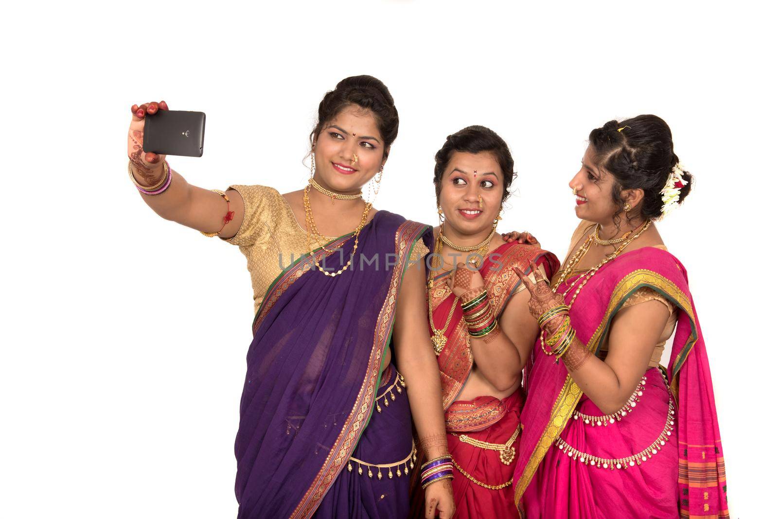 Indian traditional girls taking selfie with smartphone on white background