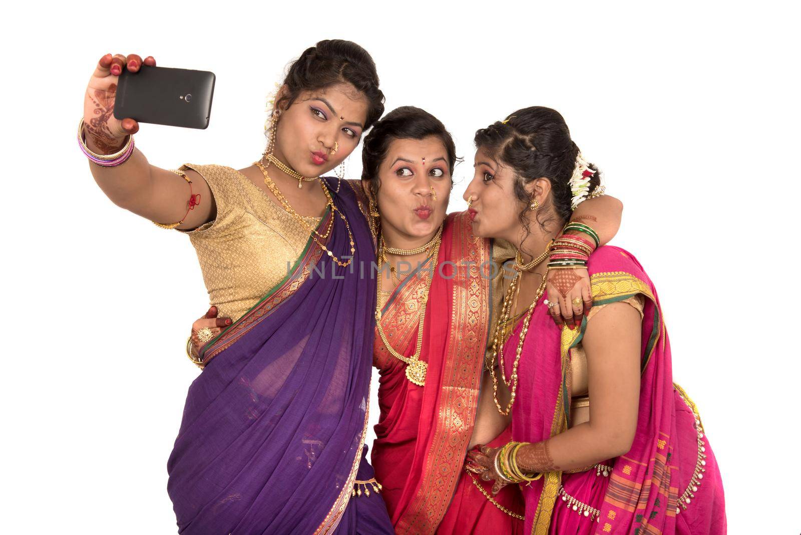 Indian traditional girls taking selfie with smartphone on white background