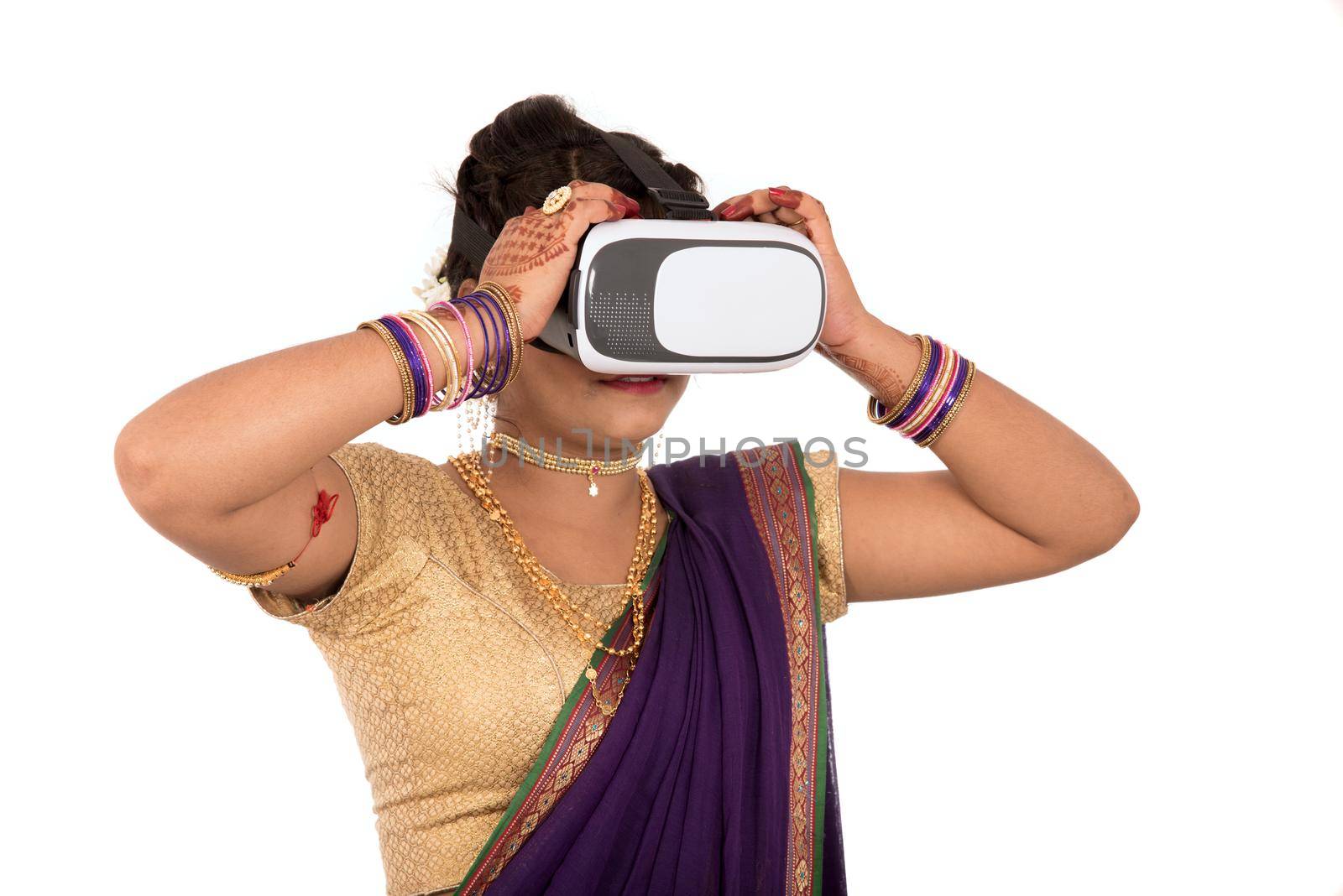 Indian traditional young woman in saree looking though VR device by DipakShelare