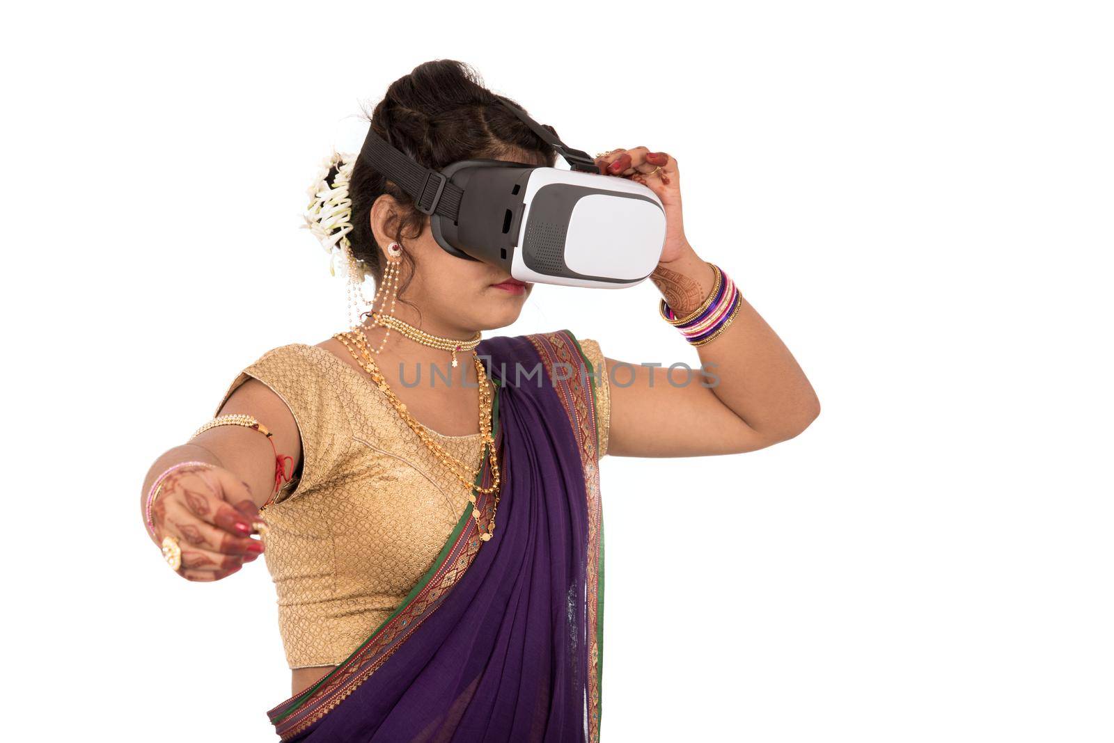 Indian traditional young woman in saree looking though VR device by DipakShelare