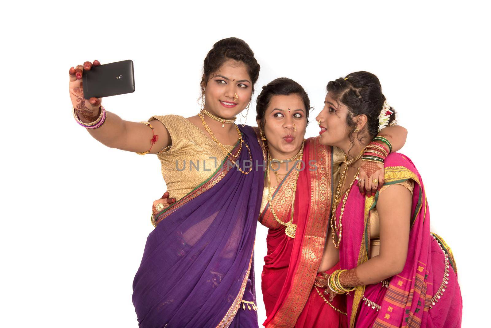 Indian traditional girls taking selfie with smartphone on white background by DipakShelare