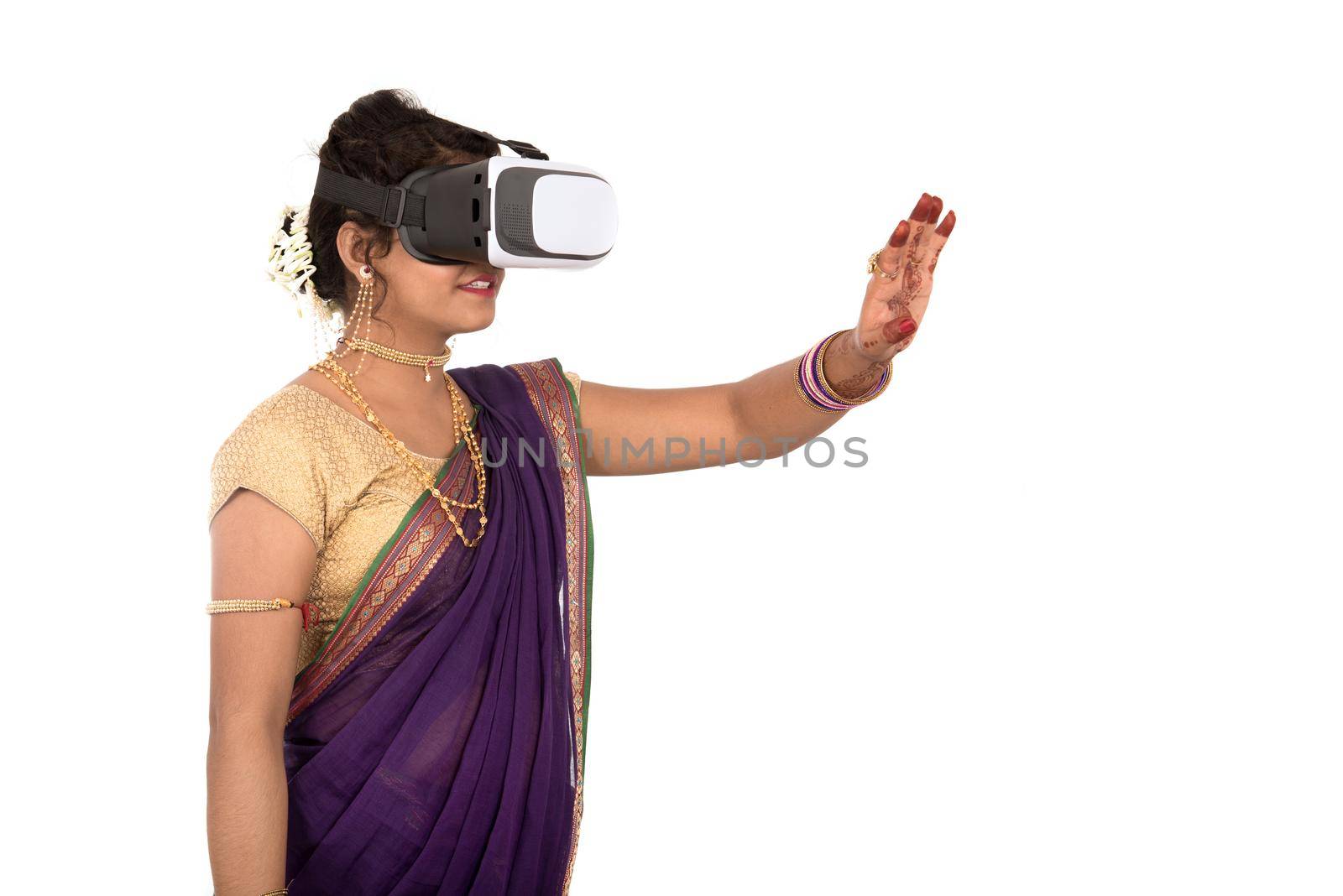 Indian traditional young woman in saree looking though VR device by DipakShelare