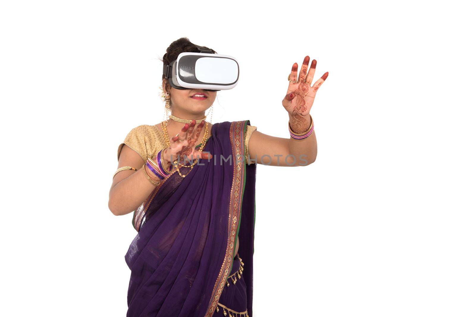 Indian traditional young woman in saree looking though VR device by DipakShelare