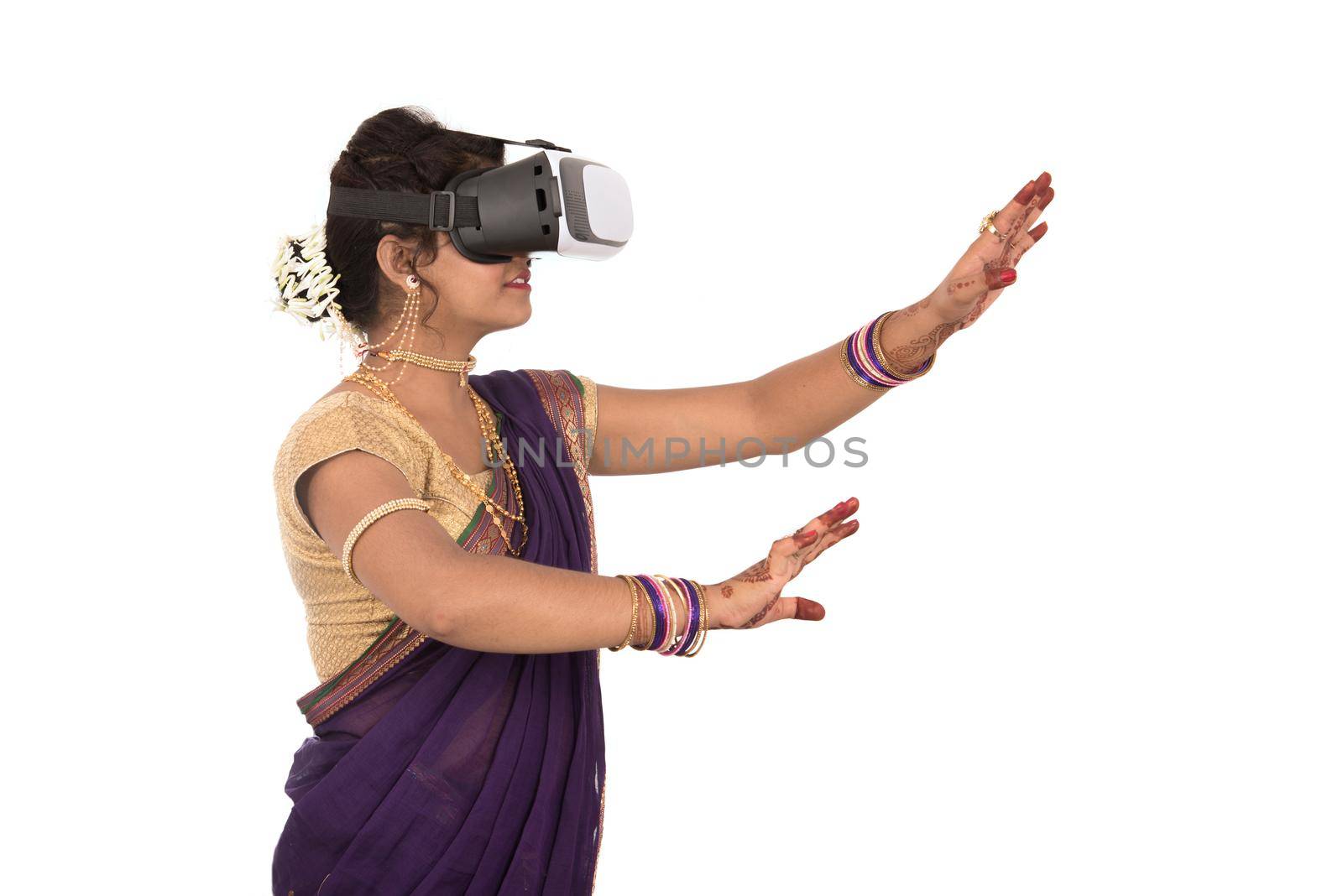 Indian traditional young woman in saree looking though VR device by DipakShelare