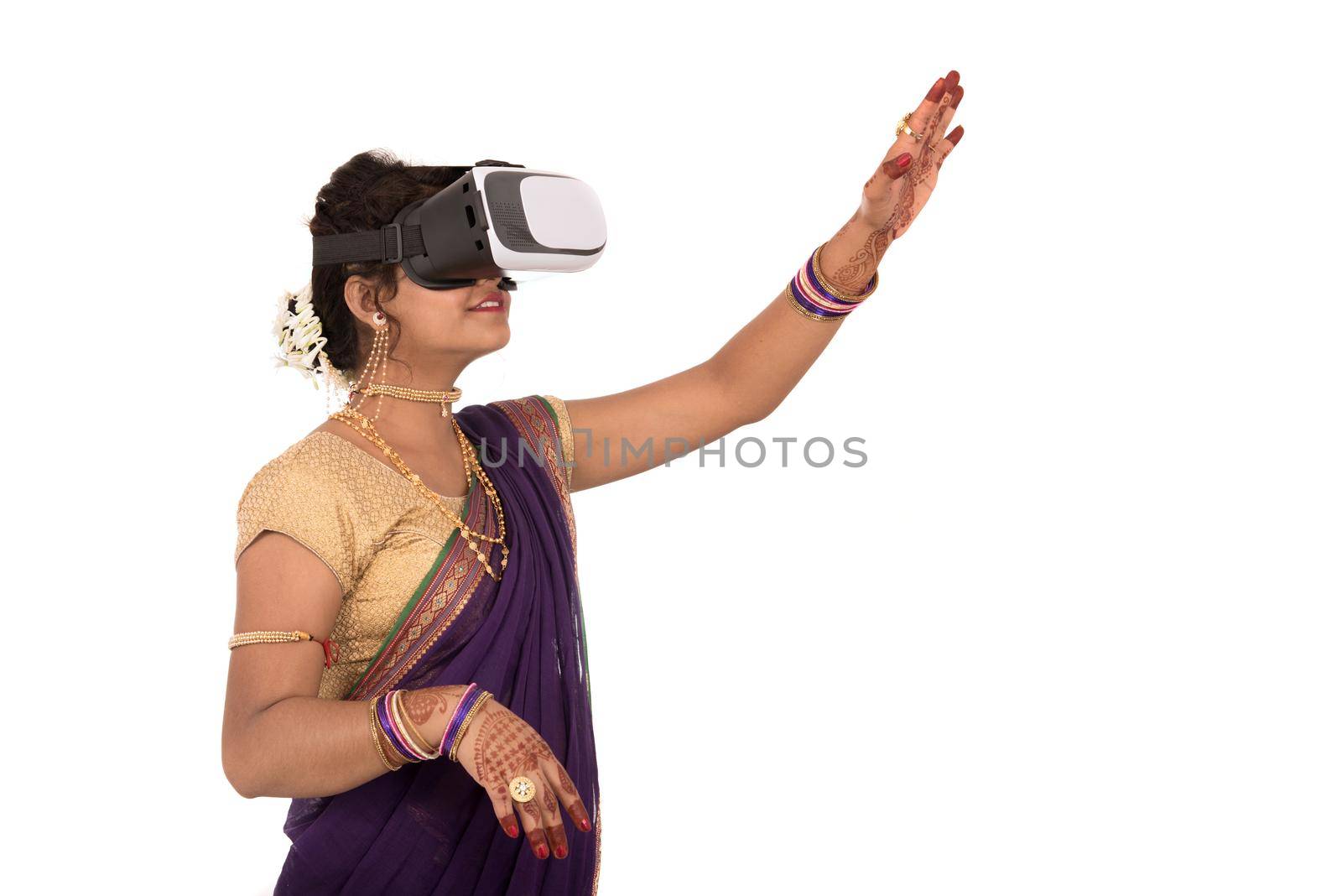 Indian traditional young woman in saree looking though VR device