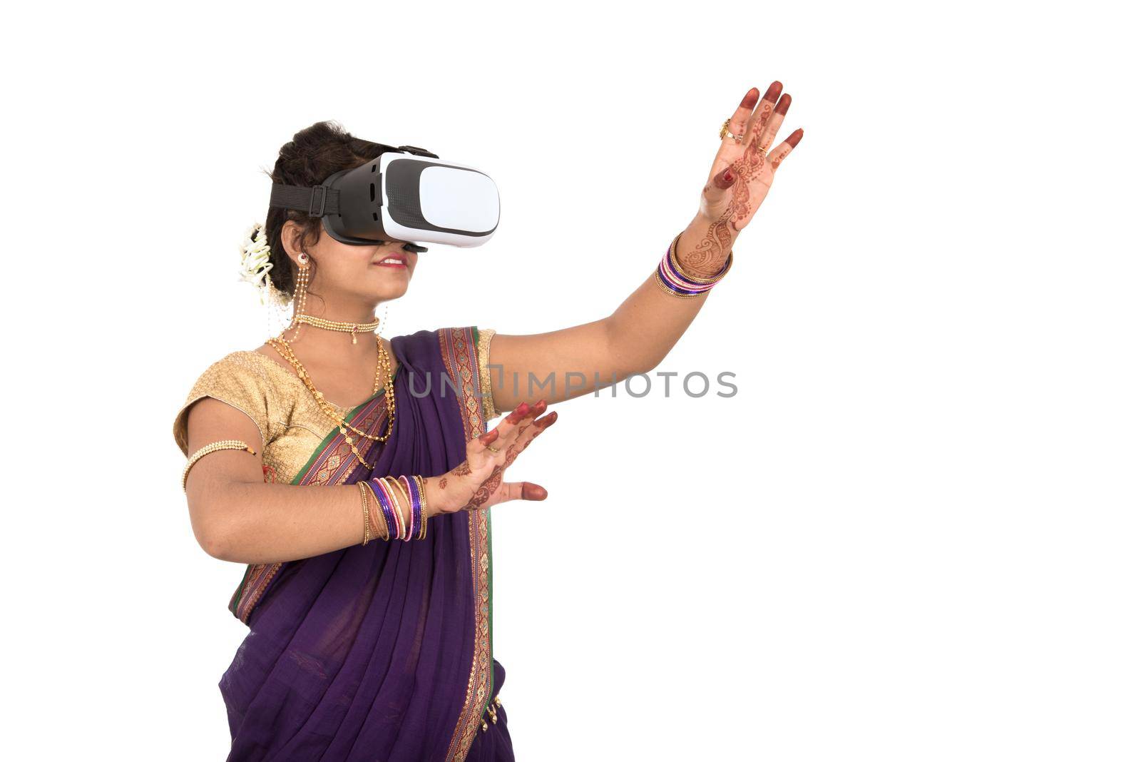 Indian traditional young woman in saree looking though VR device by DipakShelare