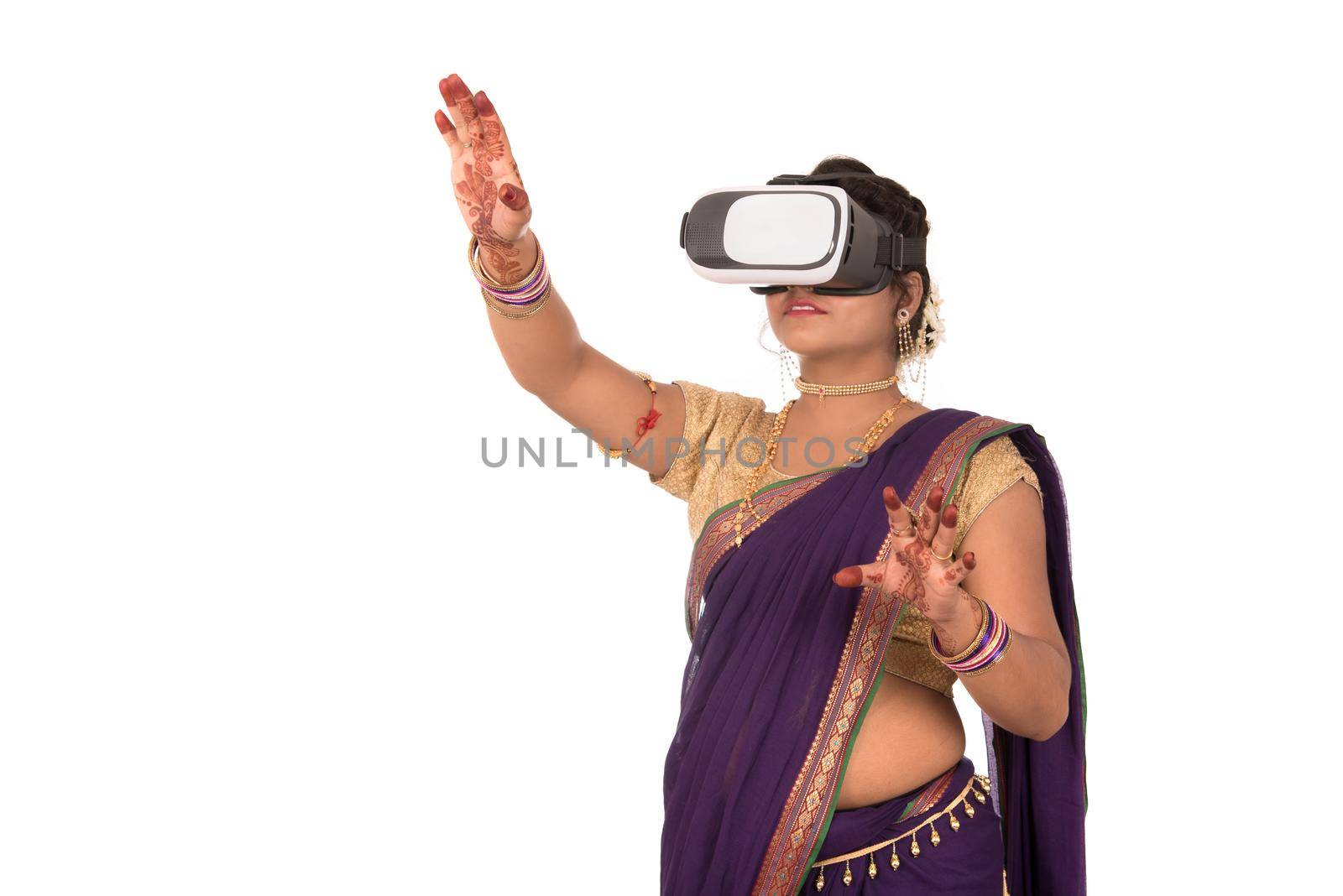 Indian traditional young woman in saree looking though VR device by DipakShelare