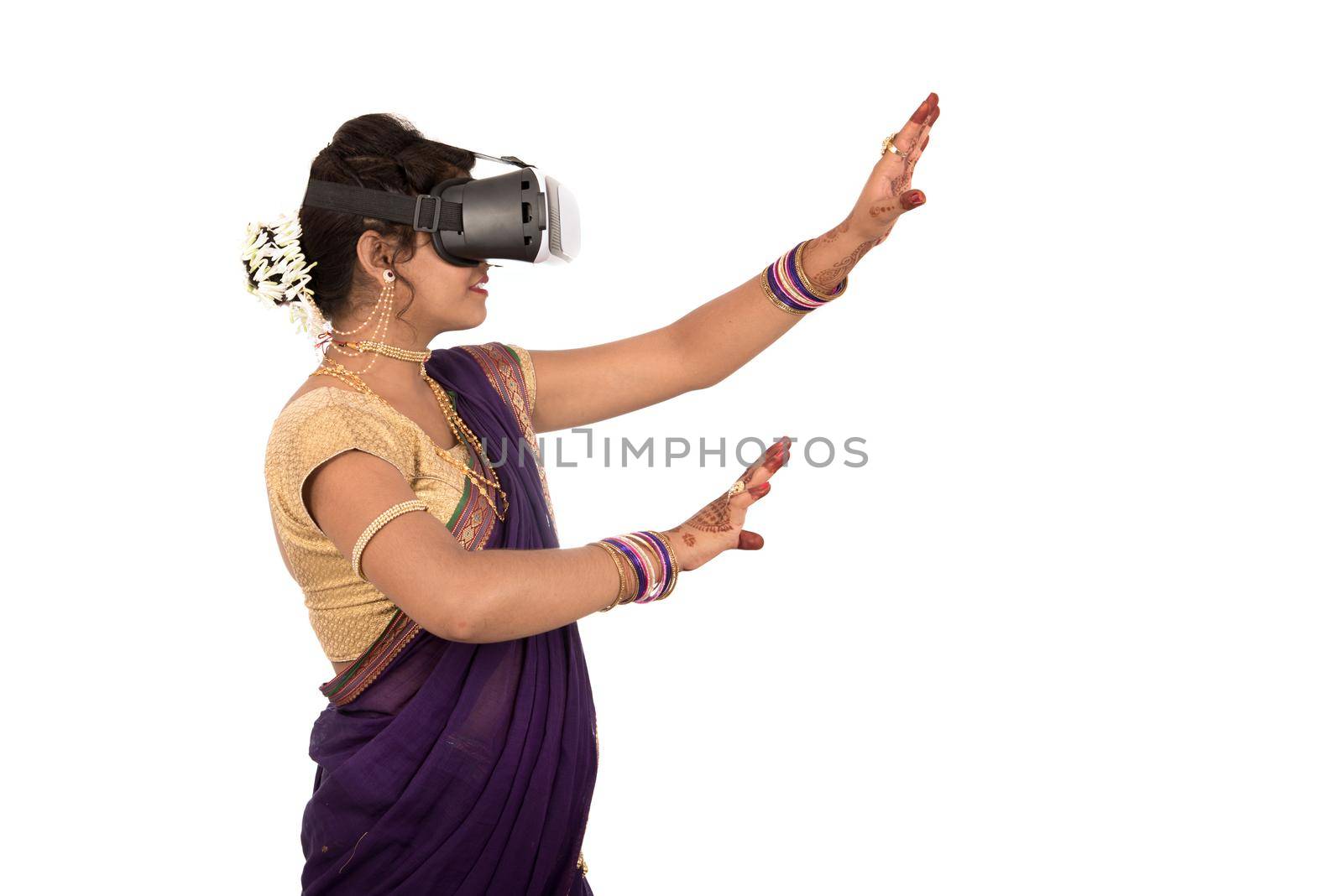 Indian traditional young woman in saree looking though VR device