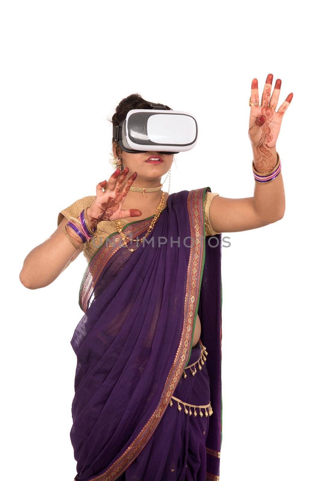 Indian traditional young woman in saree looking though VR device