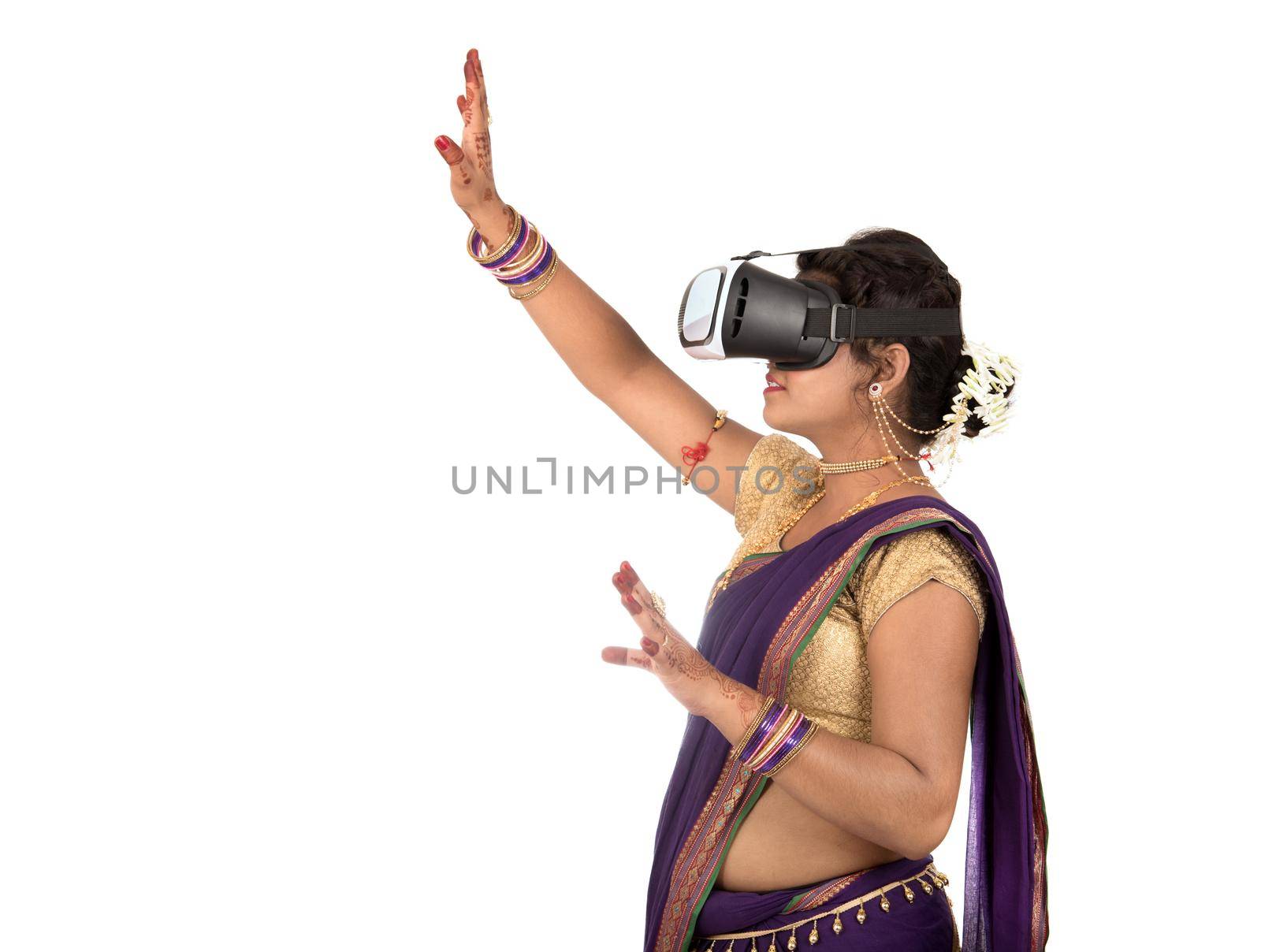 Indian traditional young woman in saree looking though VR device by DipakShelare