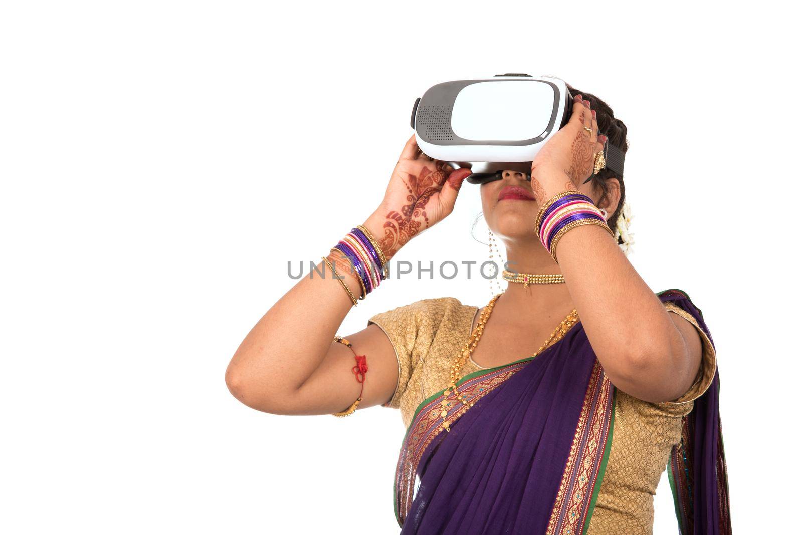 Indian traditional young woman in saree looking though VR device