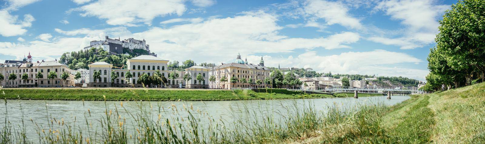 Salzburg summer time: Panoramic city landscape with Salzach with green grass and historic district by Daxenbichler