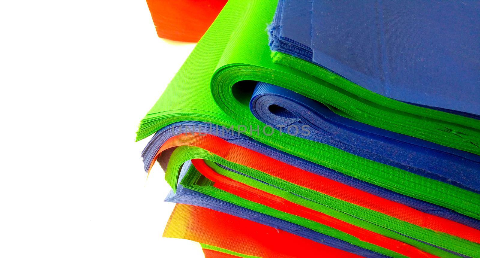 Layers of multicolored fabric in a stack on the table. Space for your text