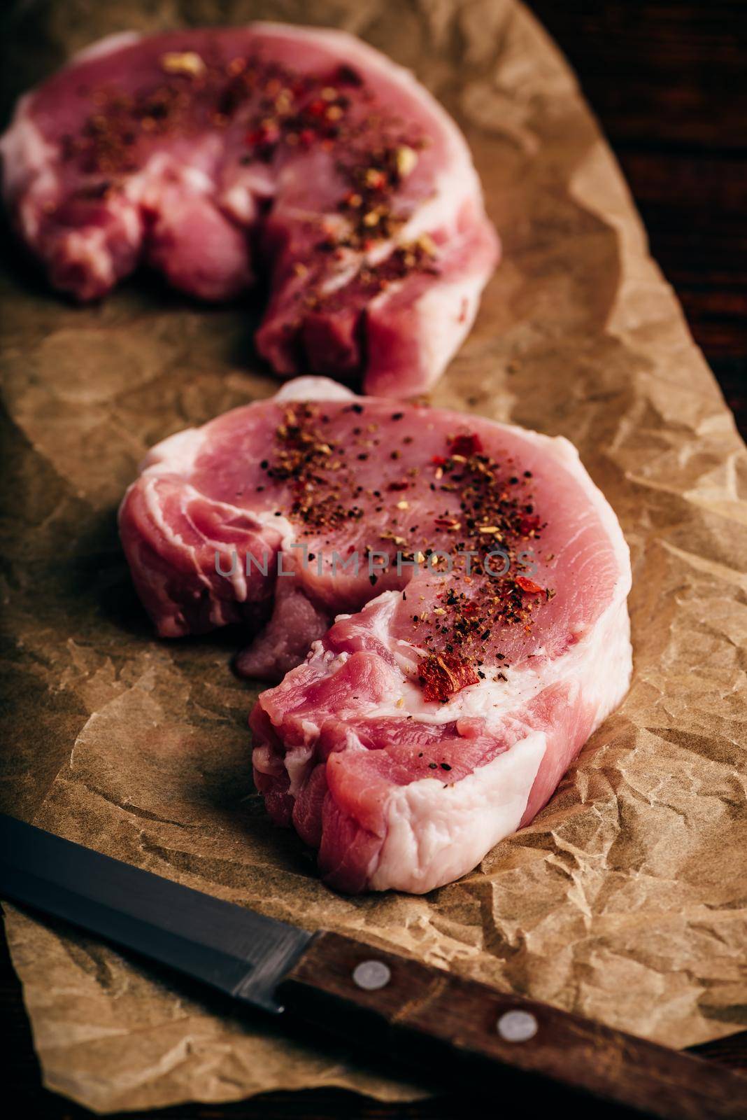 Pork loin steaks with ground spices on baking paper