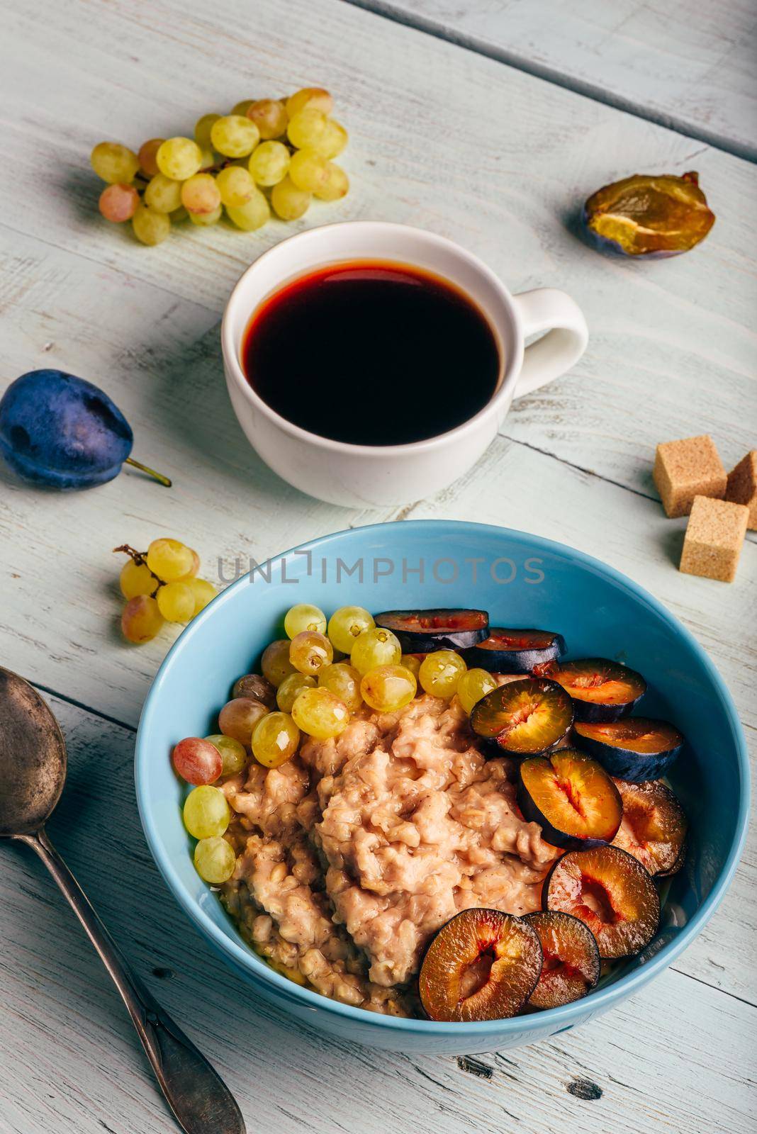 Porridge with plum, grapes and cup of coffee by Seva_blsv