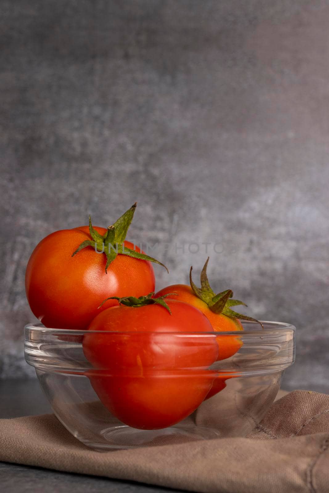 Tomatoes in salad inside a bowl on grayish background