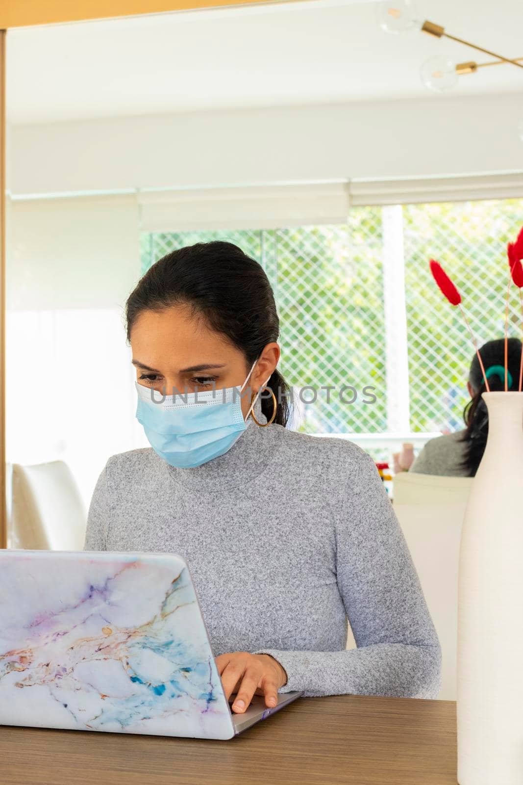 Beautiful Latin woman conducting home office for the corona virus pandemic