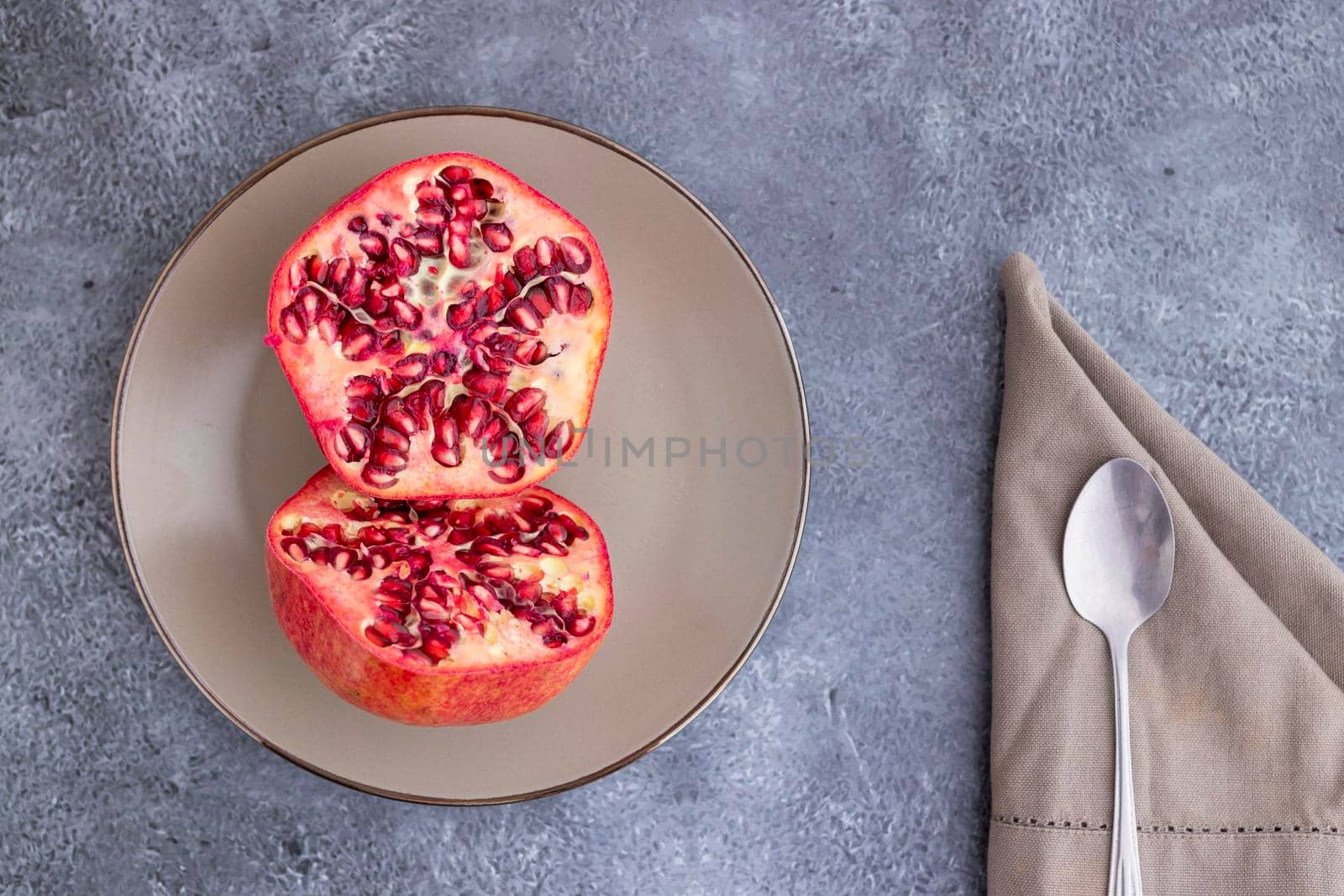 Pomegranate fruit cut in half and served on a plate