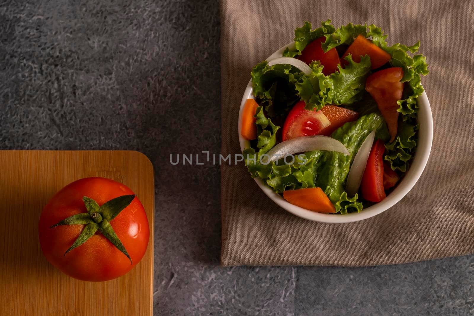 Tomatoes in salad inside a white bowl on grayish background