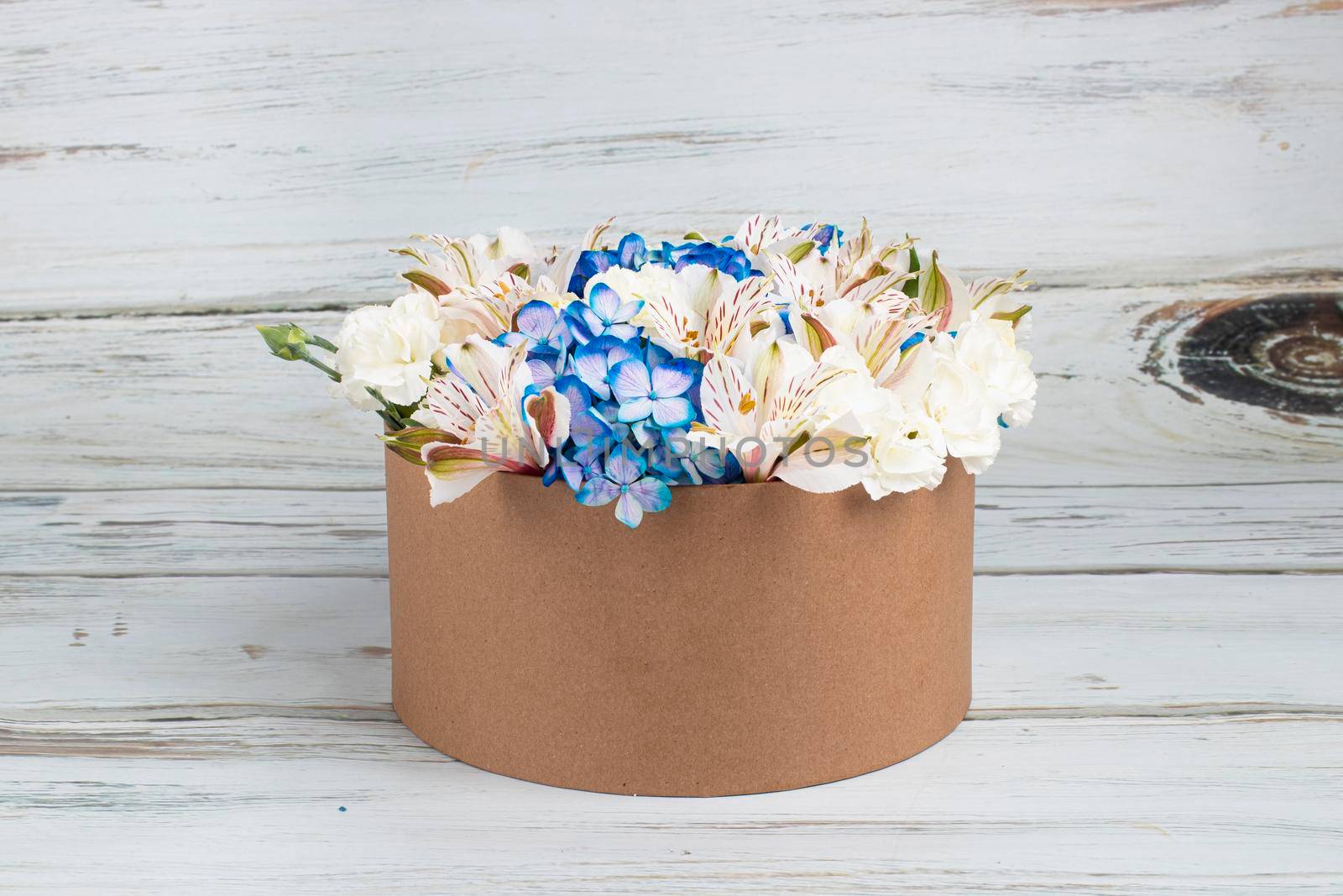 Floral arrangement with blue hydrangeas in recyclable cardboard box