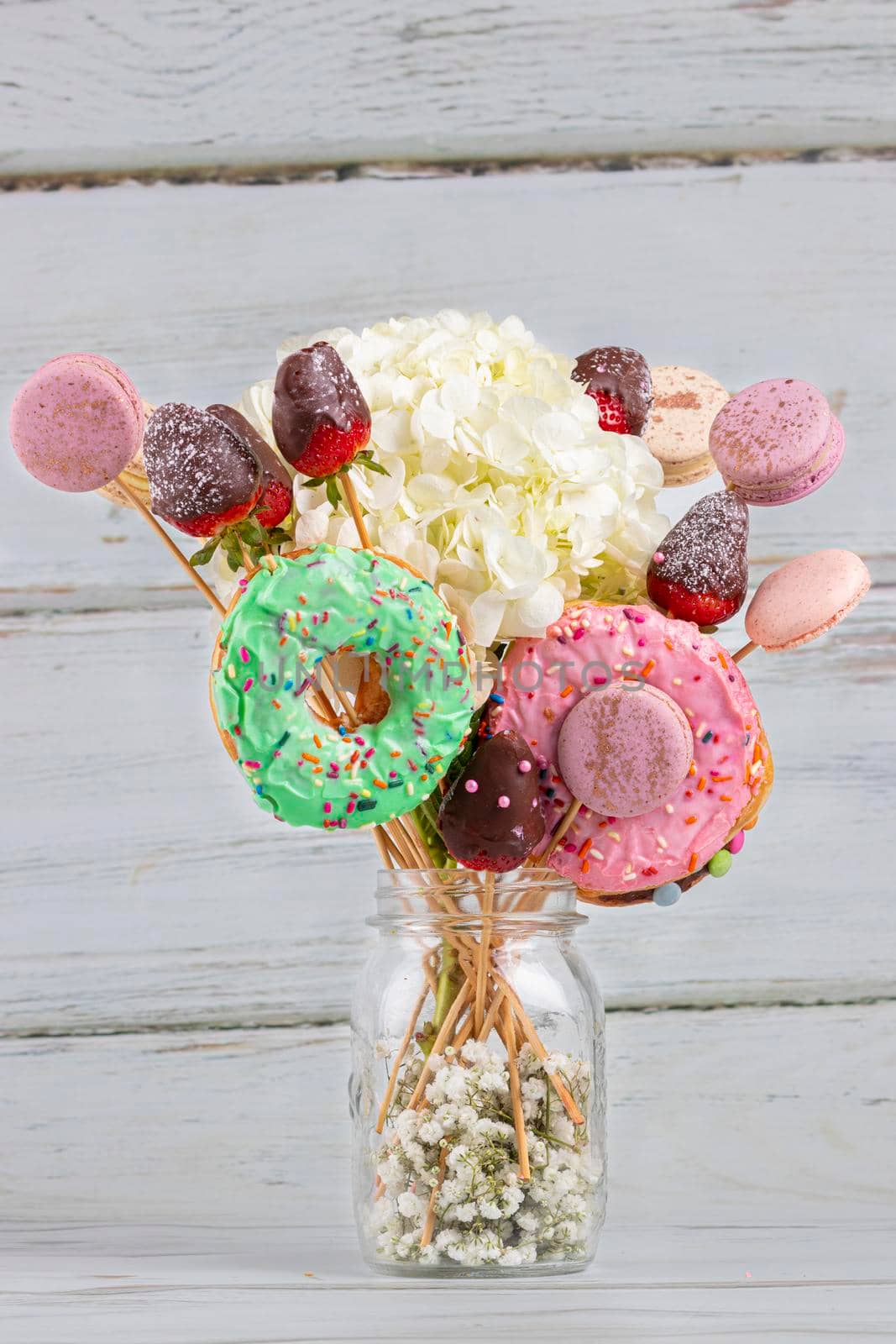 Bouquet of flowers with donuts and macarons