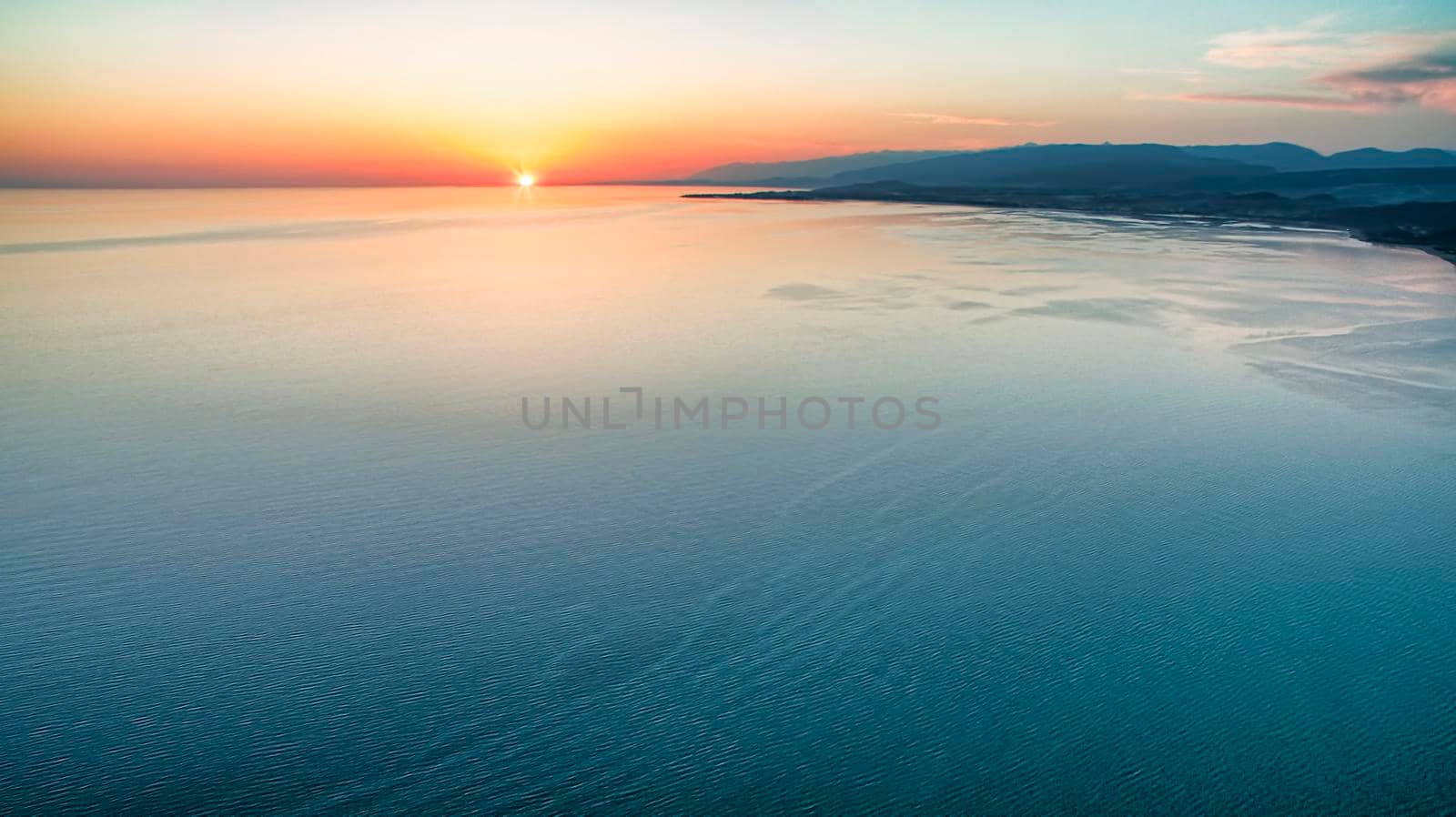 The view from the height over the sea with colorful sunset .