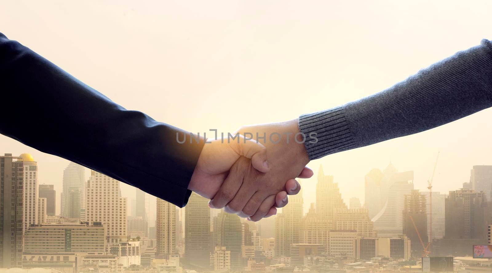 Business people shaking hands with city on background.Team and success concept. by thanumporn