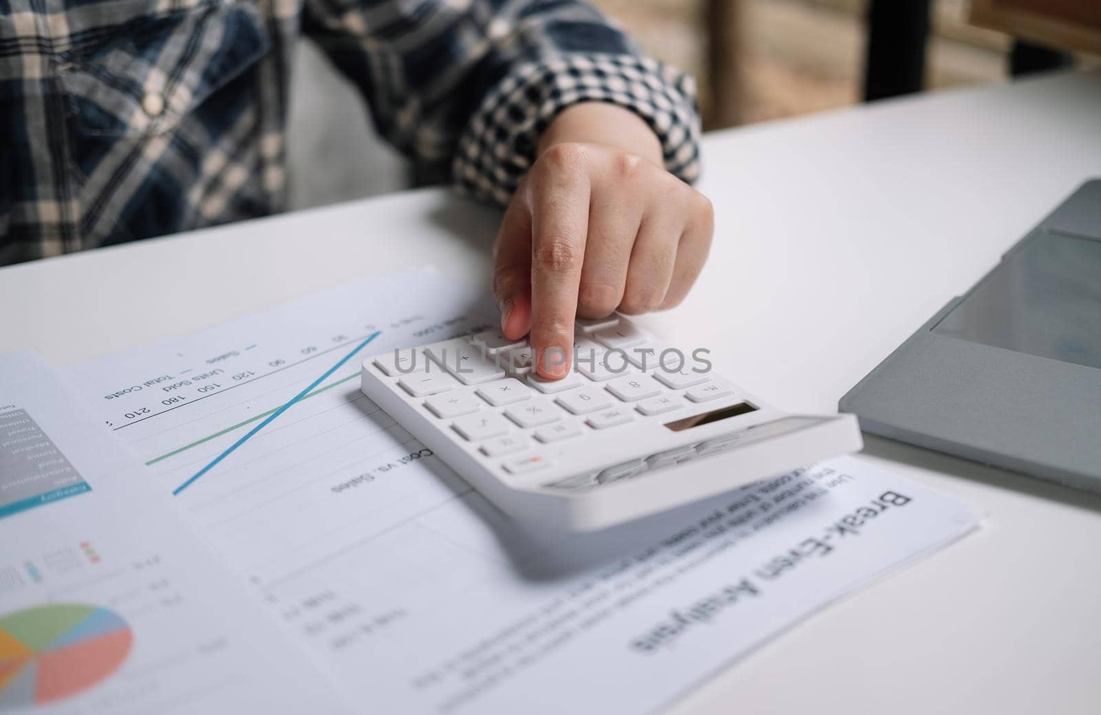 Close up of woman working with calculator or analyzing company financial report balance with augmented reality at home. Concept for business, economy, marketing and strategy, work at home