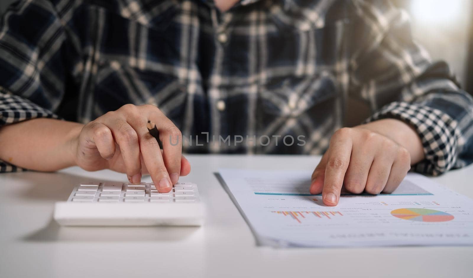 Close up of woman working with calculator or analyzing company financial report balance with augmented reality at home. Concept for business, economy, marketing and strategy, work at home