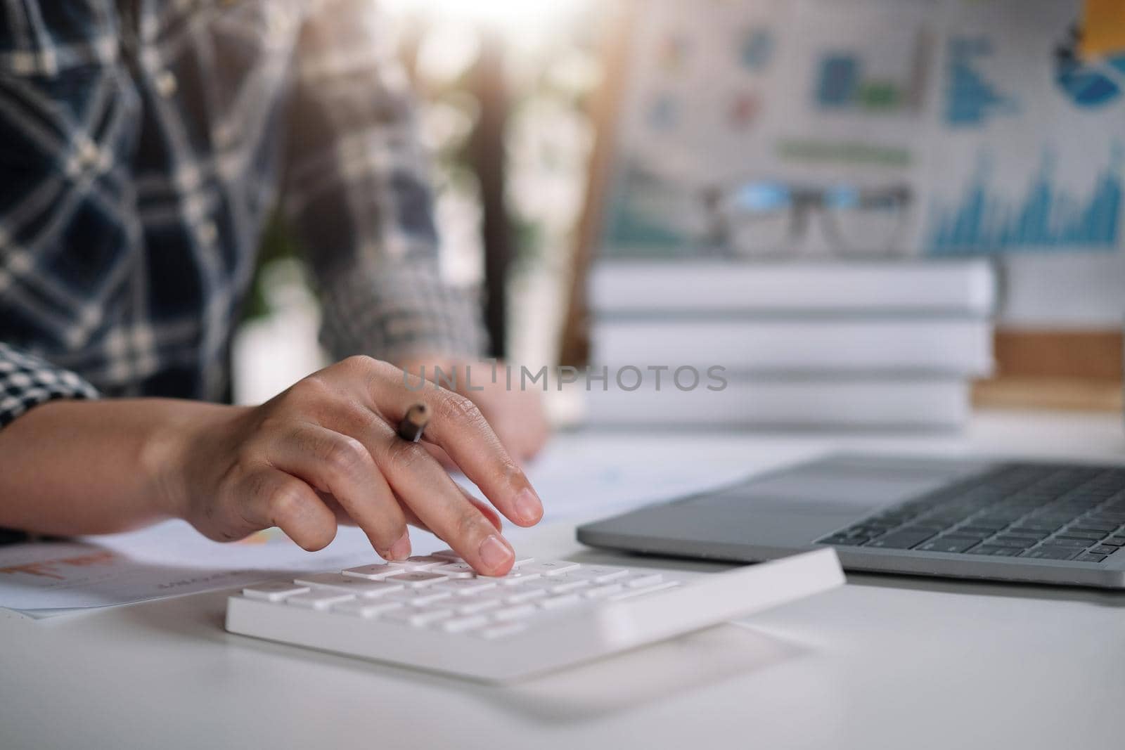 Close up hand of woman working with calculator or analyzing company financial report balance with augmented reality at home. Concept for business, economy, marketing and strategy, work at home..
