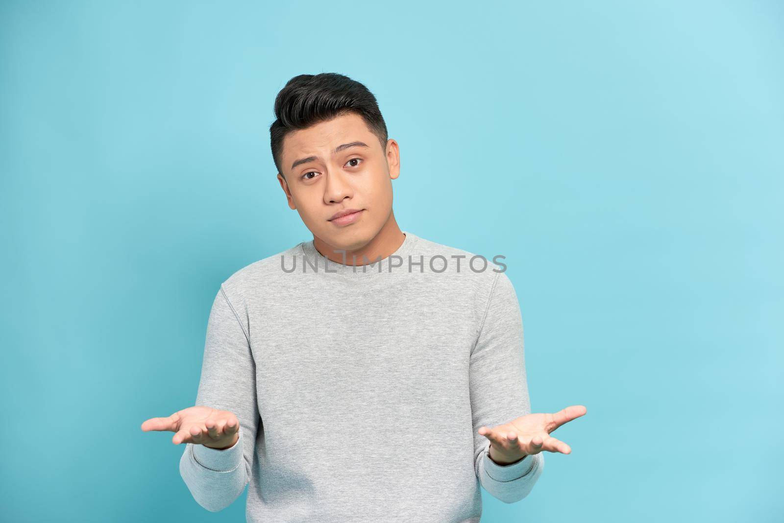 Young handsome man against a white background celebrating a victory or success, he is surprised and shocked.