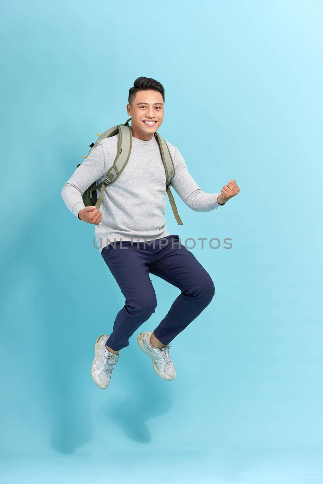 Attractive young Asian man worried and running fast to be late