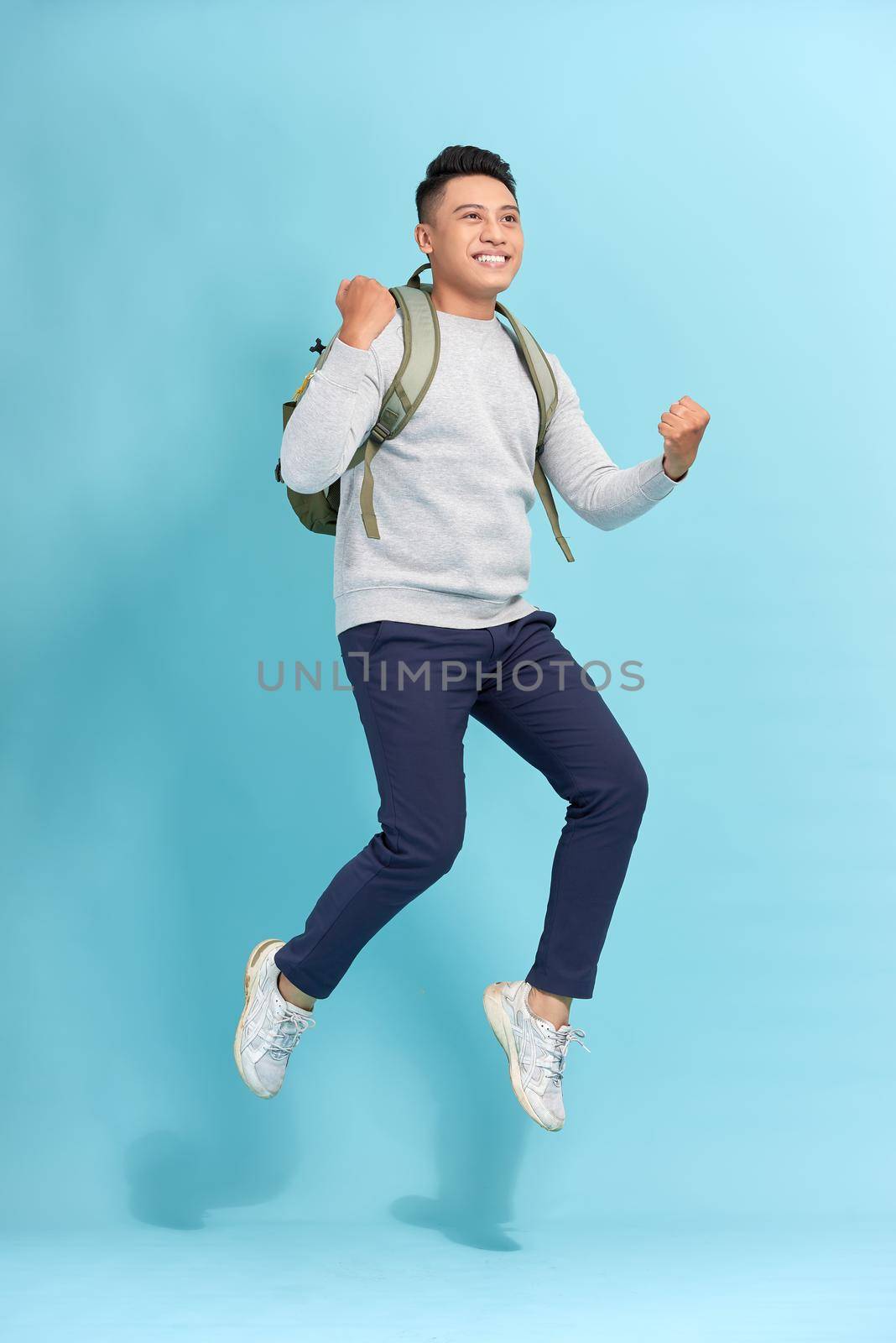 Attractive young Asian man worried and running fast to be late